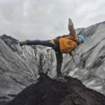 Otto the Viking guide balances on one leg on a glacier in Iceland.