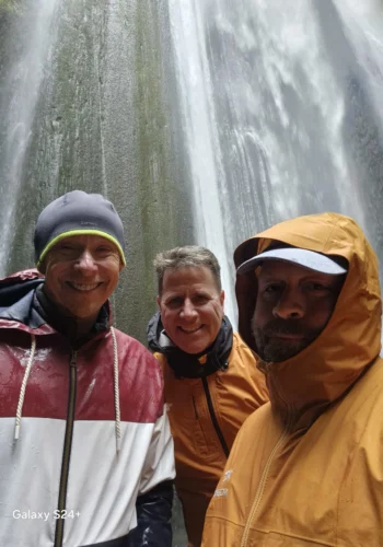 Otto the Viking with guests posing under a waterfalls in Iceland