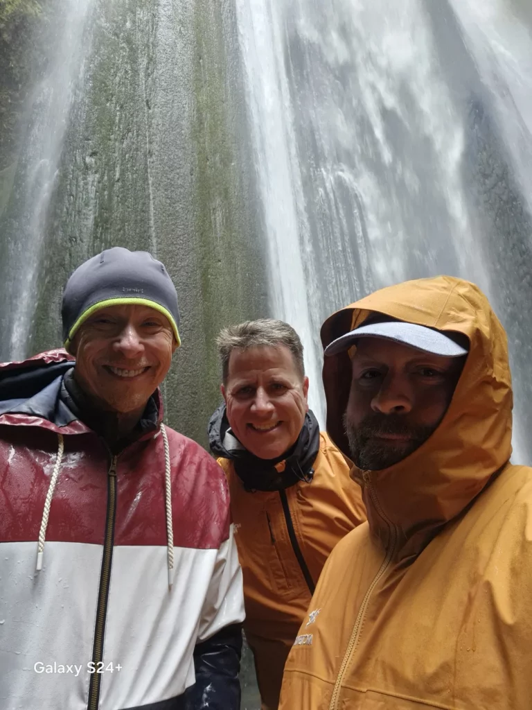 Otto the Viking with guests posing under a waterfalls in Iceland