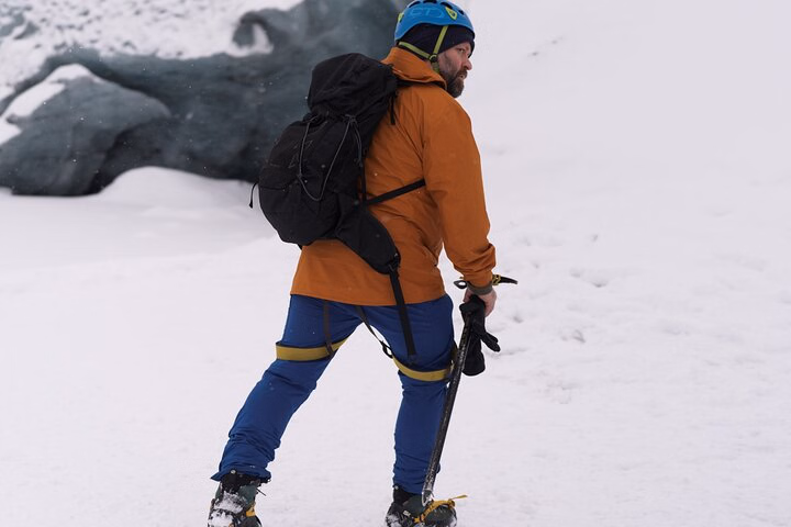 Otto, a Viking guide, hikes across snow in Iceland with an ice axe and backpack.