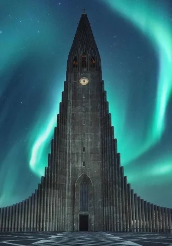 Hallgrímskirkja church framed by green northern lights in Reykjavík, Iceland.