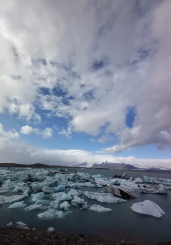 Icebergs floating on an Icelandic glacial lagoon beneath a dramatic sky.
