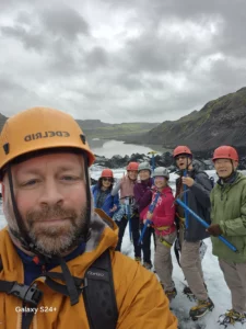 Otto the Viking and a group of hikers in helmets on an icy trail by a fjord.