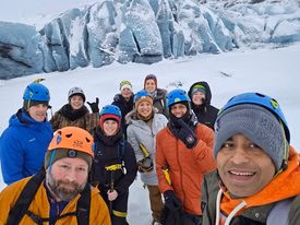 Smiling group selfie during a Sólheimajökull glacier hike in Iceland.