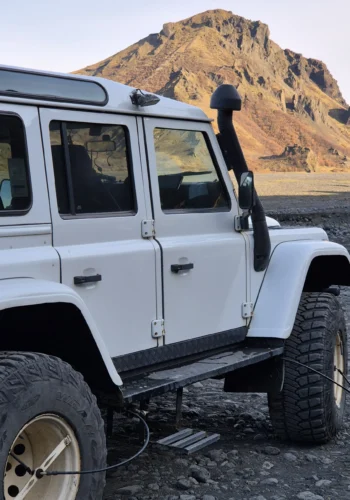White 4x4 in Thórsmörk, Iceland, with a rugged mountain behind.