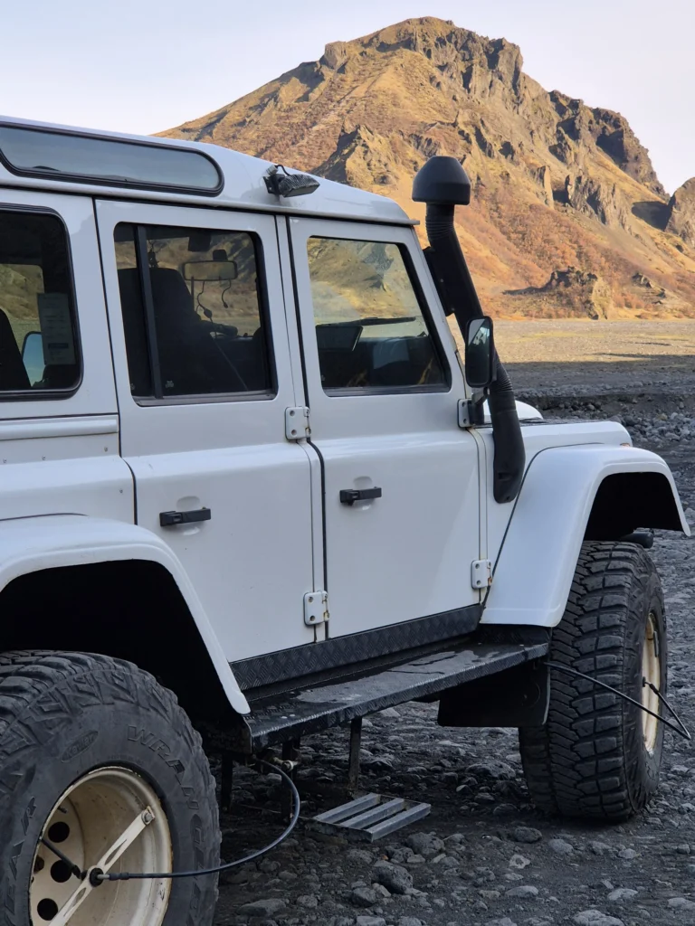 White 4x4 in Thórsmörk, Iceland, with a rugged mountain behind.